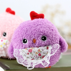 Close-up of cute plush chicks in purple and pink with lace bibs and heart crest