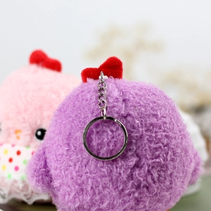 Detail of purple plush bird charm featuring a soft texture and silver keychain ring