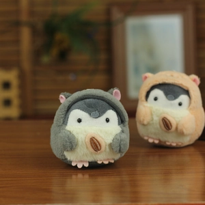 Detail of plush penguin keychains in animal hoodies with sunflower seed embroidery