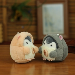 Detail of plush penguin keychains in orange and grey with soft fur texture and bead chain