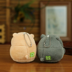 Detailed back view of plush penguin charms with green clover patches on wooden surface