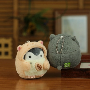 Front and back view of a plush penguin keychain with pink hoodie on wooden surface