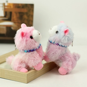 Detail of pink and blue alpaca plush charms with beaded collars and metal keyrings