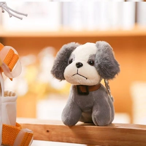 Close-up of cute grey and white plush puppy keychain with a premium leather collar