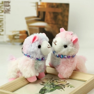 Detail of plush alpaca keychains with soft colorful fur and bead collars on wood