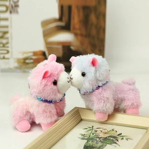 Close-up of pink and blue plush alpaca keychains with colorful bead collars and soft fur