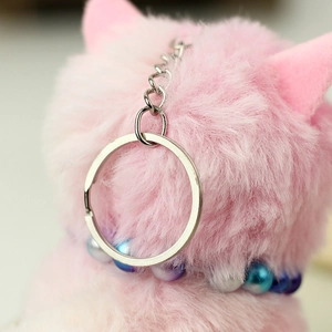 Close-up of pink fluffy plush cat keychain with beaded collar and silver metal ring