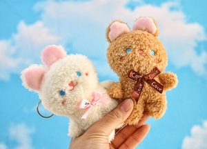 Dettaglio dei ciondoli a forma di coniglio in peluche con morbida pelliccia e ricami fini