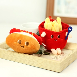 Detail von Plüsch-Hotdog und Pommes-Schlüsselanhängern mit Stickerei auf Holztablett