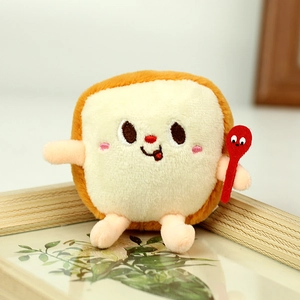 Detailaufnahme einer Plüsch-Toast-Puppe mit Stickerei und einem kleinen roten Löffel