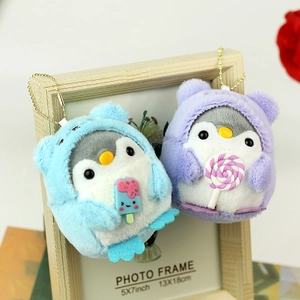 Detail of plush penguin keychains with soft texture and candy accessories in blue and purple