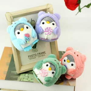 Detail of colorful plush penguin pendants with gold chains and miniature dessert accessories