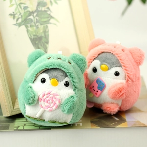Close-up of plush bear dolls in penguin hoodies holding candy and popsicle on books