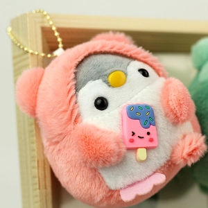 Close-up of plush penguin keychain in pink fluffy hoodie holding a cute popsicle charm