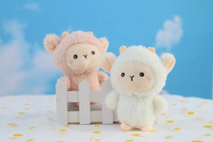 Dettaglio di ciondoli a forma di agnello in peluche con texture riccia e visi ricamati