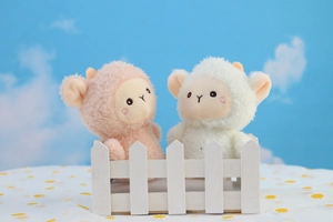 Dettaglio di pecorelle di peluche rosa e bianche con pelliccia morbida e guance rosa