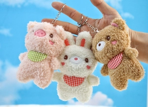 Close-up of three plush animal keychains with checkered scarves and metal rings