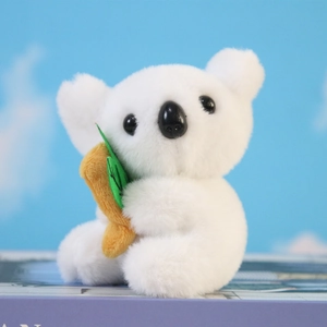 Dettaglio di un mini koala di peluche bianco con una fogliolina verde tra le zampe