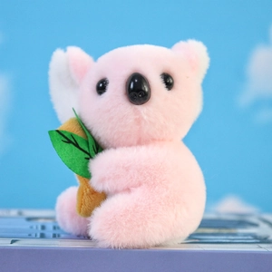 Dettaglio del peluche di koala rosa che tiene una foglia verde con trama morbida