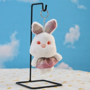 Gros plan d'un porte-clés lapin en peluche blanche avec oreilles à carreaux roses et anneau