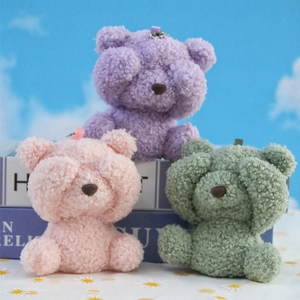 Three plush shy bears in pastel purple, pink, and green with metal chains for backpacks