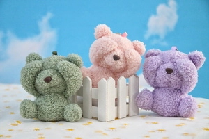 Three plush teddy bear charms in green, pink and purple with soft metallic chains