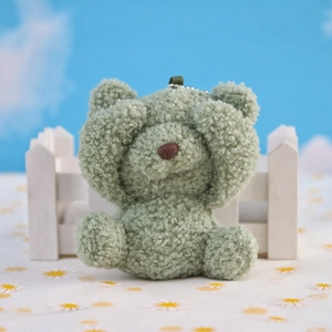 Detailed view of shy green plush bear keychain with sherpa texture and bead chain
