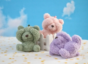 Detailed view of plush shy bear keychain charms in green, pink, and purple lamb wool