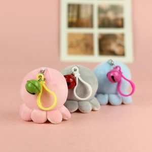 Close-up of cute plush octopus charms in pink, grey and blue with bells and hooks