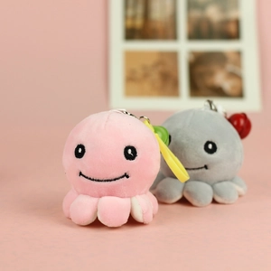 Close-up of pink and grey plush octopus pendants with metal keyrings and yellow spring clips