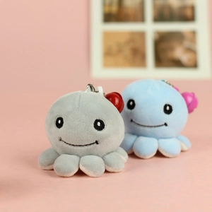 Detail of mini plush octopus keychains with embroidery eyes and metal hooks in two colors