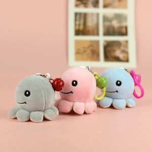 Detail of plush octopus keychains in grey, pink and blue with colorful bells and clips