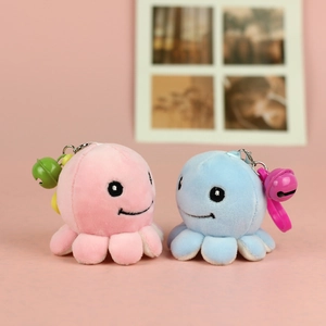 Close-up of cute pink and blue plush octopus charms with colorful metal bells and hooks