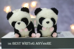 Zwei Panda Plüsch-Anhänger aus weichem Kunstfell auf einem Buch sitzend