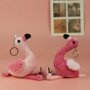 Close-up of pink flamingo plush keychains with soft fur and metal rings on a pink background