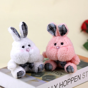 Close-up of plush rabbits with British plaid details on ears and paws on a book