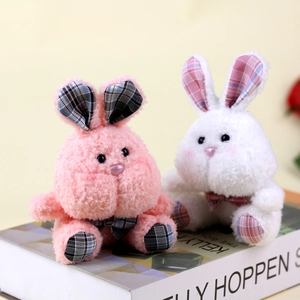 Detail showing plush rabbit charms with plaid ear accents on decorative book props