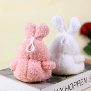 Detail of cute plush bunny keychains in pink and white with soft fluffy texture