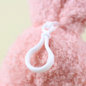 Detail of soft plush pink rabbit charm with white plastic teardrop hook and strong stitching
