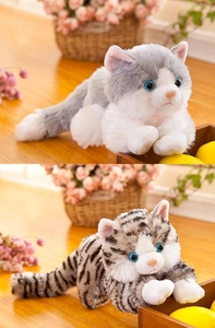 Vista dettagliata di gatti di peluche realistici grigi e tigrati con occhi blu su legno