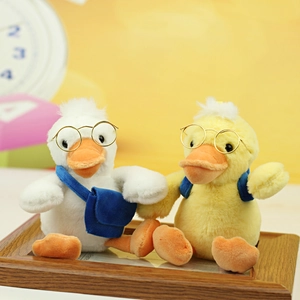 Close-up of plush duck toy set featuring round glasses and miniature blue backpacks