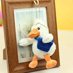 Close-up of cute plush duck with round gold glasses and a mini blue crossbody bag