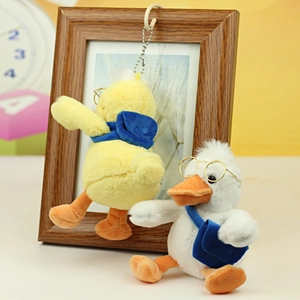 Detail of yellow plush duck with blue scarf and glasses featuring a metal chain hook
