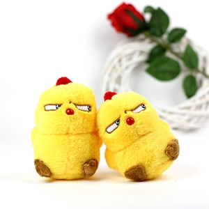 Close-up of two funny yellow plush chick keychains with grumpy facial expressions