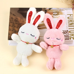 Detail of plush bunny charms with glitter ears, red silk ribbon, and small golden bells