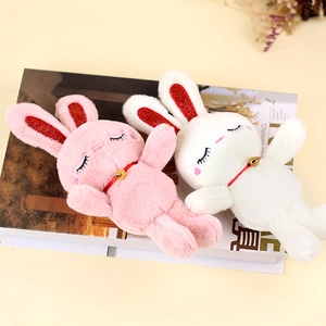 Detailed macro view of cute plush bunny keychains with shiny red ears and golden bells