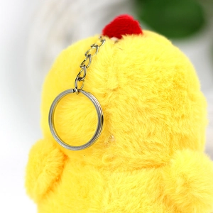Detail of the soft yellow plush chicken keychain with a silver metal ring and fluffy texture