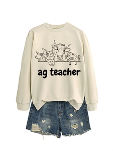 Close-up of ag teacher farm animal print on beige crewneck sweatshirt and denim shorts