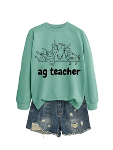 Detail view of mint green ag teacher sweatshirt featuring farm animal sketches and denim shorts