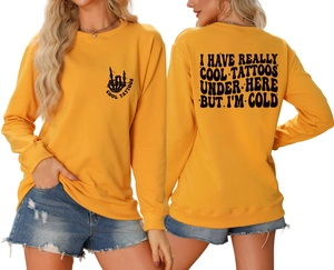 Detail of yellow sweatshirt featuring black skull hand and Cool Tattoos back typography